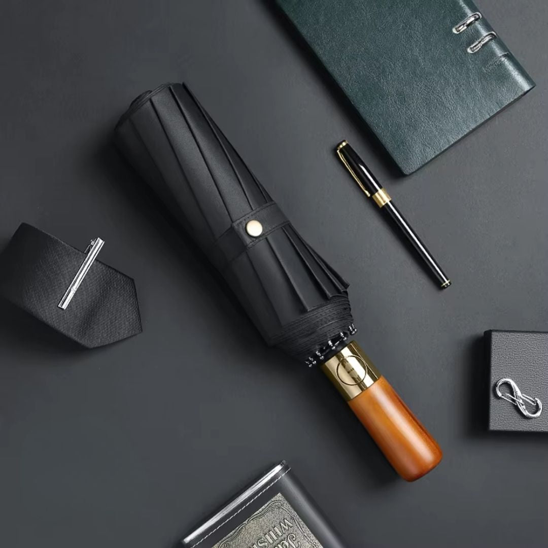 NertZ.in Royal Shield umbrella with a wooden handle and gold accents, surrounded by a tie, pen, and notebook