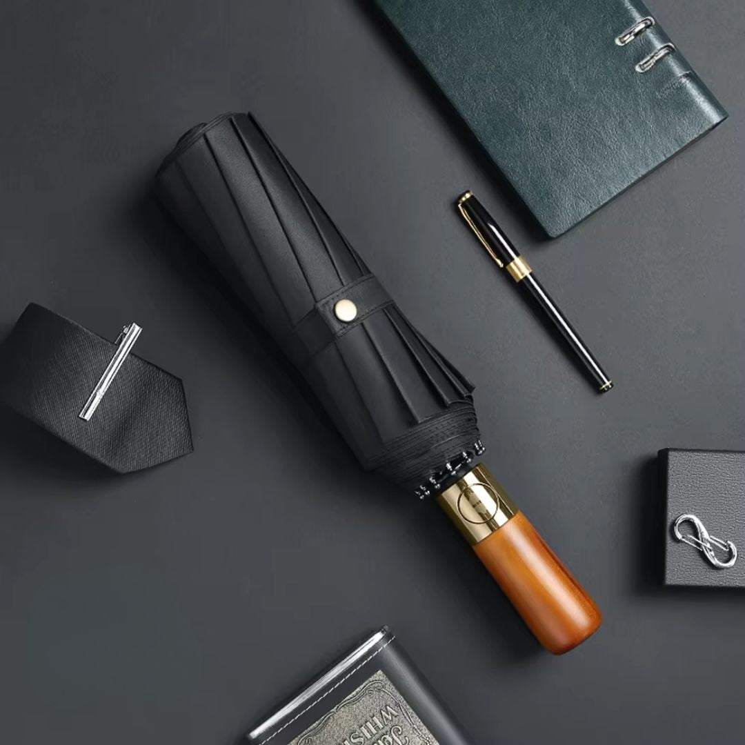 NertZ.in Royal Shield umbrella with a wooden handle and gold accents, surrounded by a tie, pen, and notebook